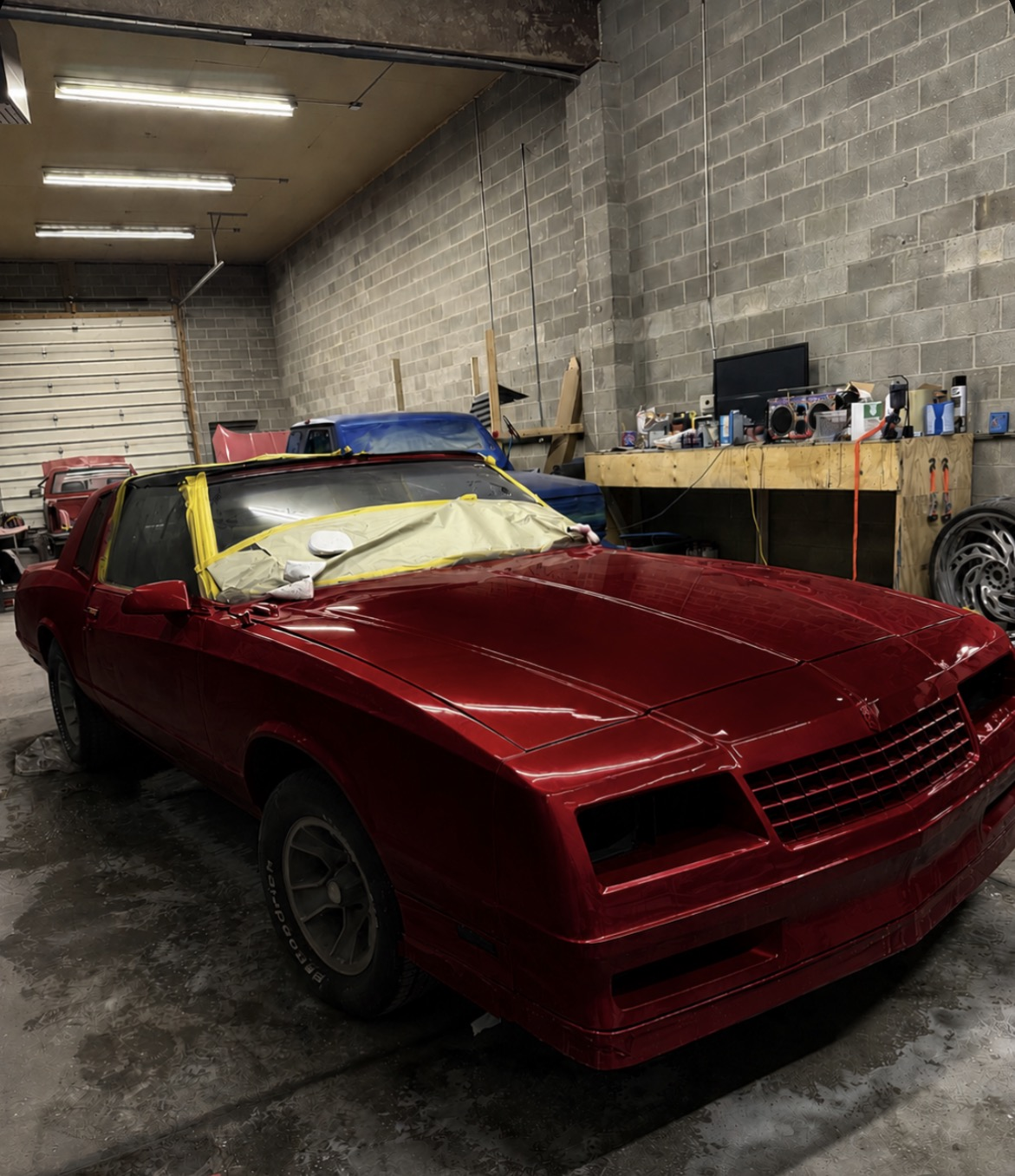 Freshly painted candy-red Chevrolet Monte Carlo inside the Eli's Auto shop